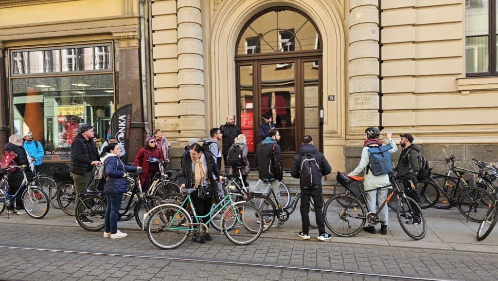 Eine große Gruppe Menschen mit Fahrrädern versammeln sich vor der Antidiskrimidierungsstelle in Halle.